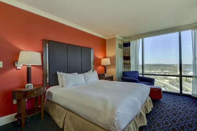 bedroom with ornamental molding and dark carpet