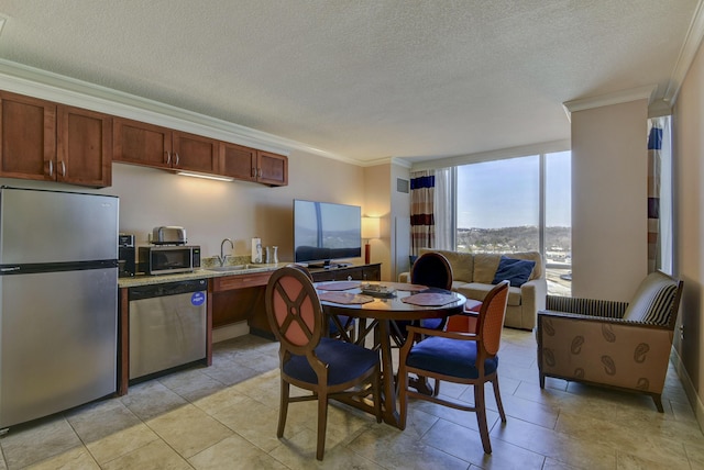 kitchen featuring sink, stainless steel appliances, crown molding, and a textured ceiling