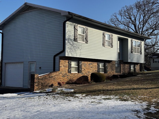 view of snow covered exterior with a garage