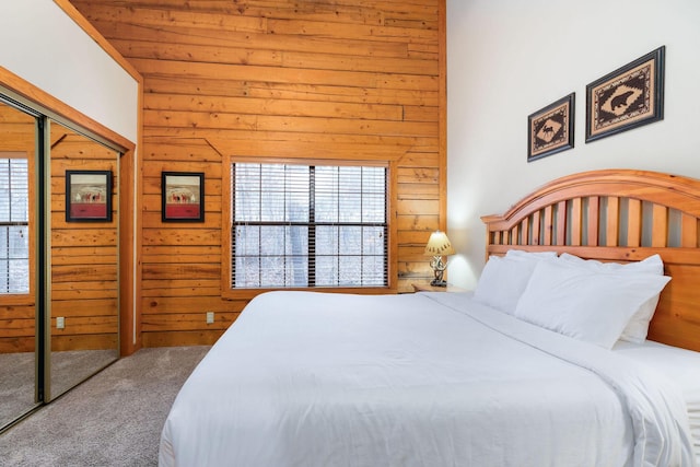 bedroom with multiple windows, a closet, and wooden walls