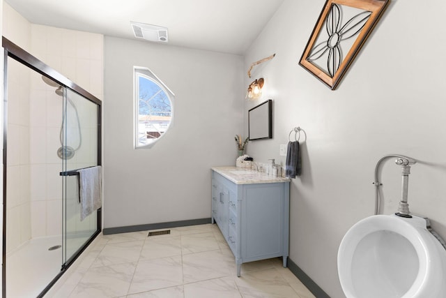 bathroom featuring a shower with shower door and vanity