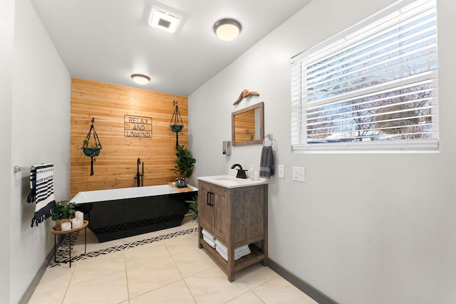 bathroom with vanity, tile patterned floors, wood walls, and a bath