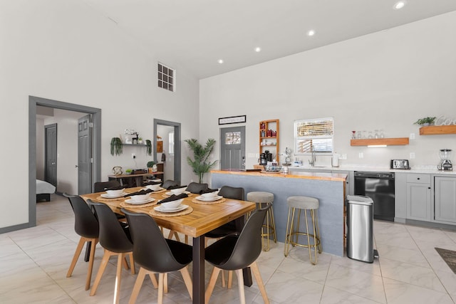 dining room featuring a high ceiling and bar