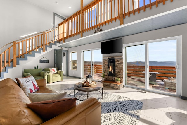 tiled living room with a fireplace and a high ceiling