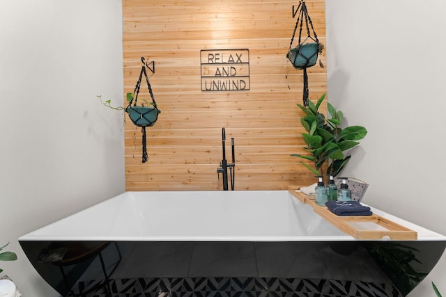 details featuring tiled tub and wood walls