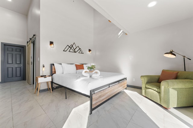 bedroom with a barn door and a high ceiling