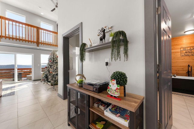 corridor featuring light tile patterned floors and wooden walls