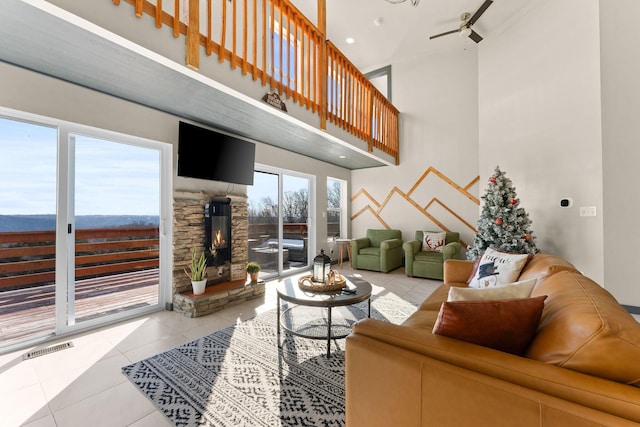 tiled living room with ceiling fan and a towering ceiling