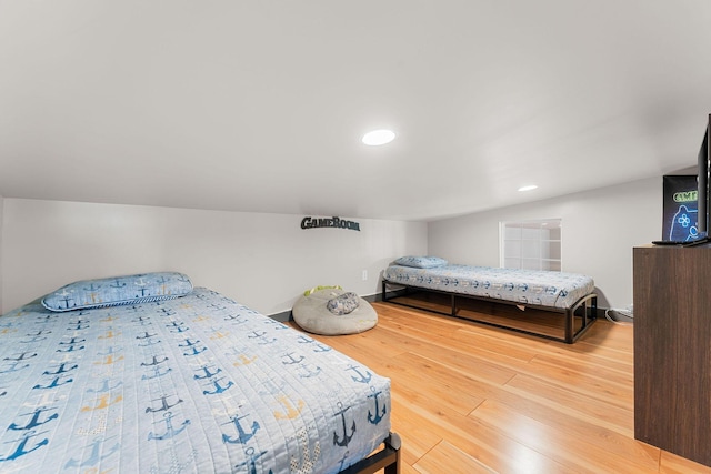 bedroom with vaulted ceiling and hardwood / wood-style flooring