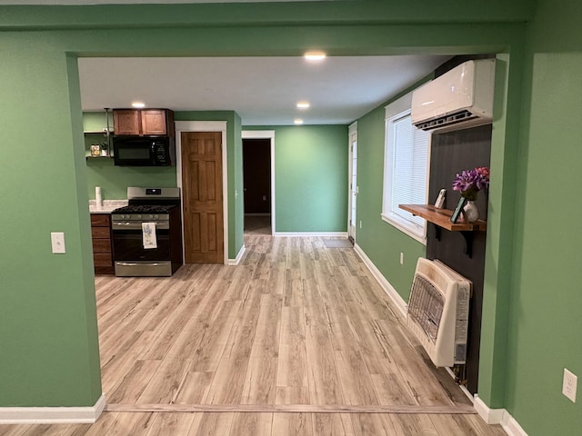 hallway with heating unit, light hardwood / wood-style flooring, and an AC wall unit