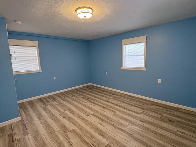 empty room featuring wood-type flooring and a textured ceiling