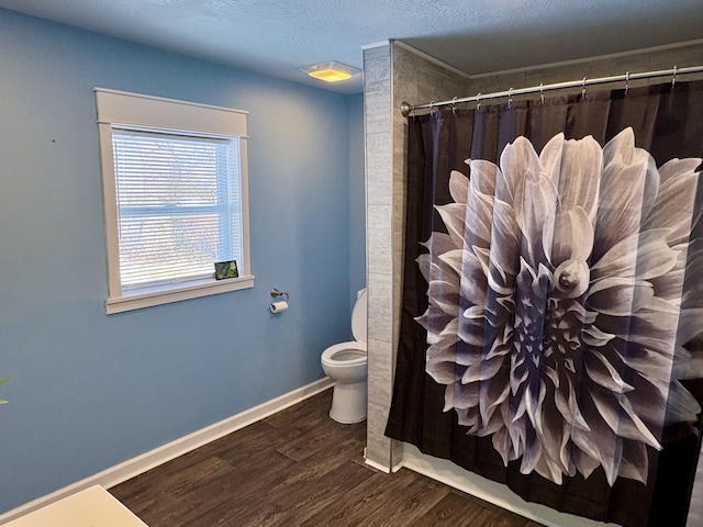 bathroom with toilet, wood-type flooring, and walk in shower