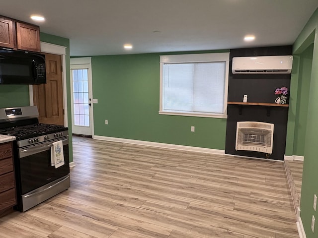 kitchen with a fireplace, gas stove, light hardwood / wood-style floors, a wall unit AC, and heating unit