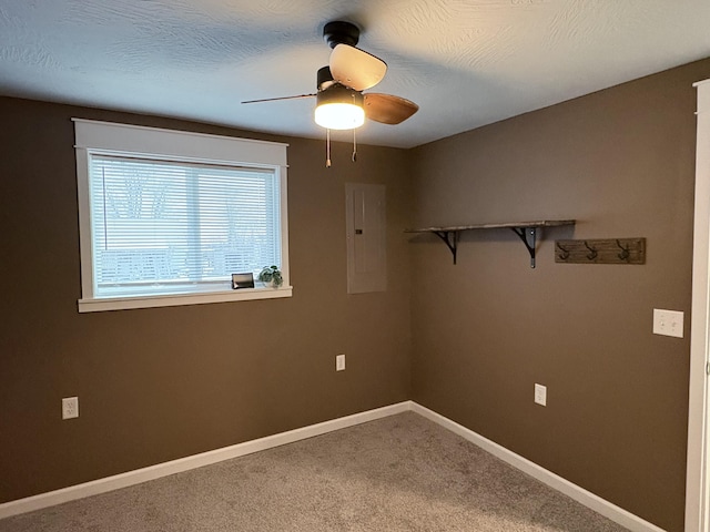 carpeted spare room with ceiling fan, a textured ceiling, and electric panel