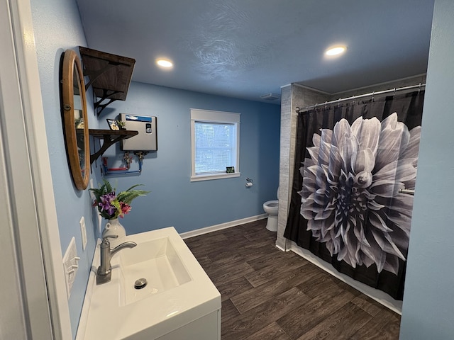 bathroom featuring toilet, hardwood / wood-style floors, vanity, and curtained shower