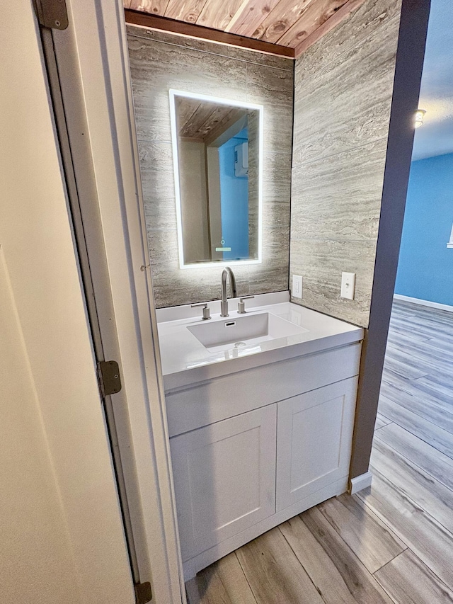 bathroom with hardwood / wood-style floors, vanity, and wooden ceiling