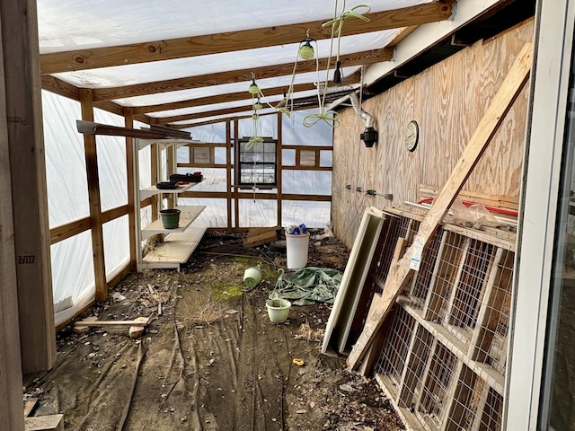 miscellaneous room with wood walls and vaulted ceiling with beams