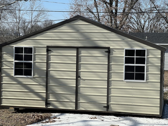 snow covered structure featuring a garage