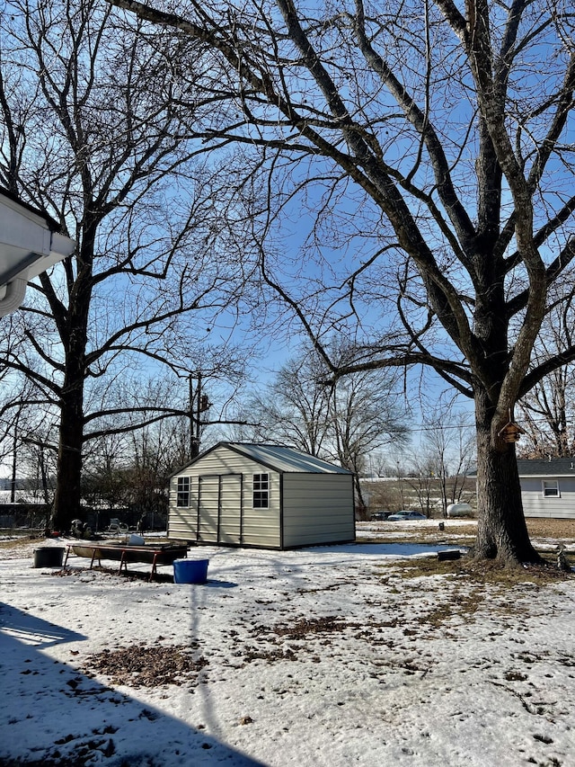 yard covered in snow with a storage shed