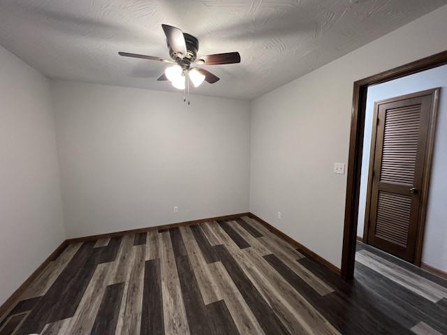 unfurnished room with ceiling fan, dark wood-type flooring, and a textured ceiling