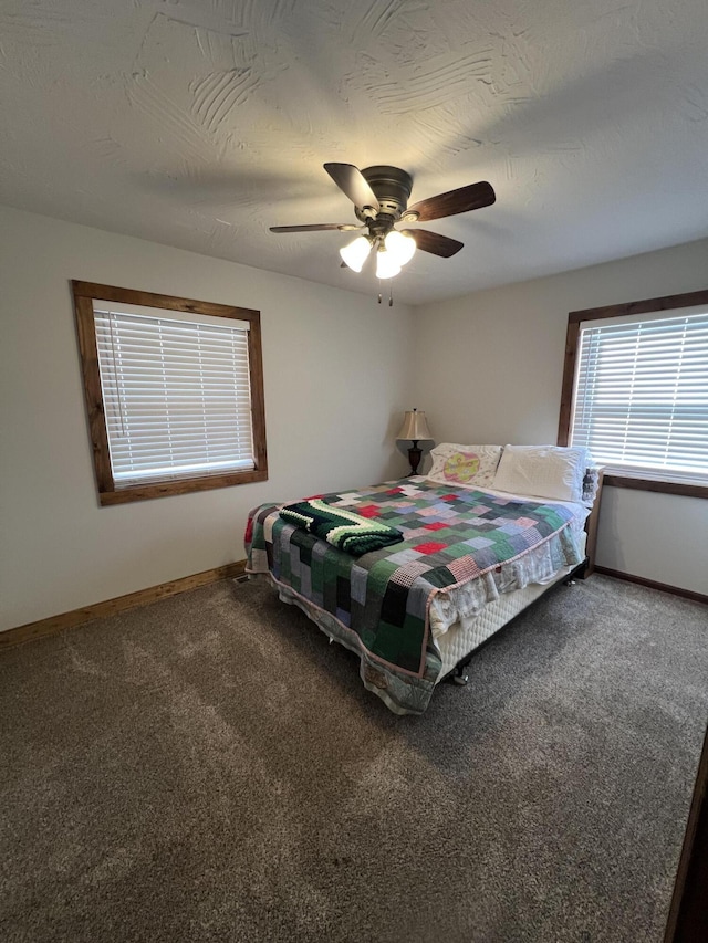 bedroom with ceiling fan, carpet floors, and a textured ceiling