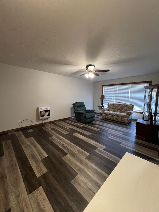 unfurnished living room with heating unit, dark hardwood / wood-style flooring, a textured ceiling, and ceiling fan