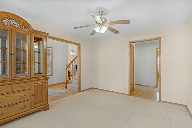 empty room with ceiling fan and light colored carpet