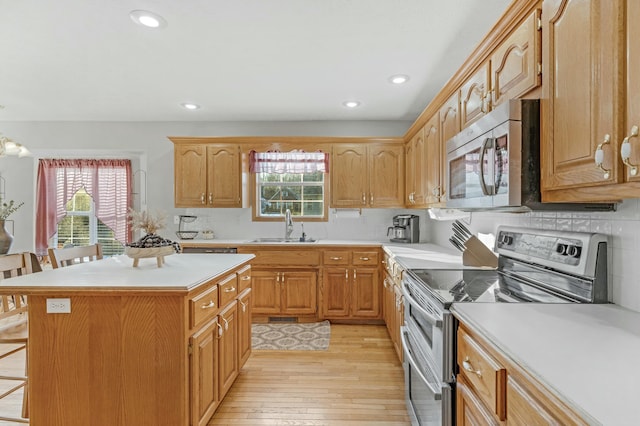 kitchen with a kitchen breakfast bar, sink, stainless steel appliances, and a kitchen island