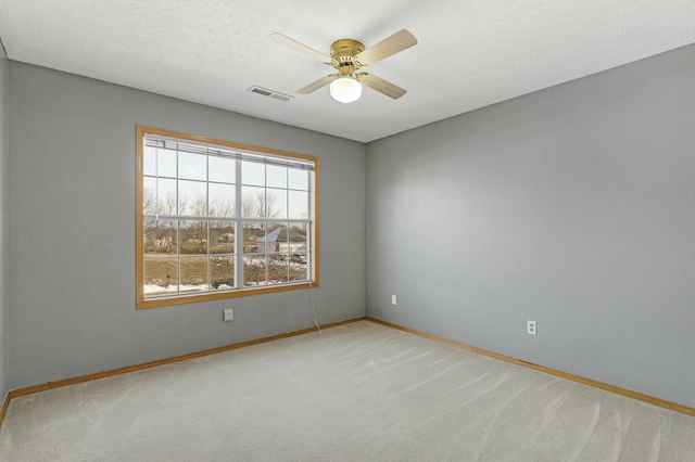 carpeted spare room with ceiling fan and a textured ceiling