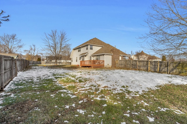 snow covered rear of property with a deck