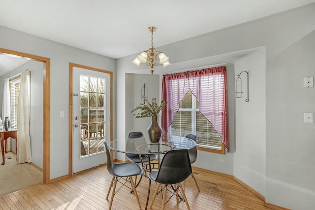 dining space featuring a notable chandelier, plenty of natural light, and hardwood / wood-style flooring