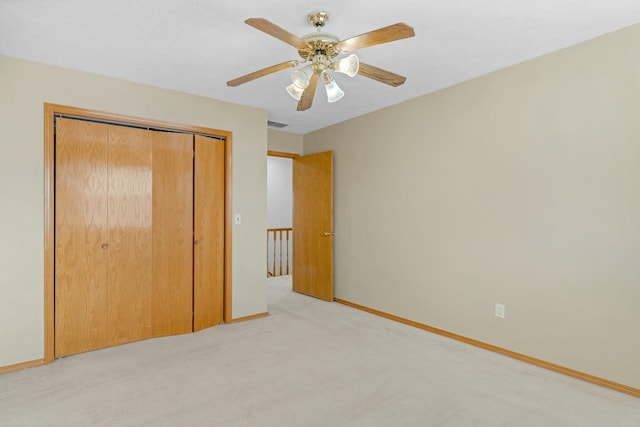 unfurnished bedroom featuring ceiling fan, a closet, and light carpet