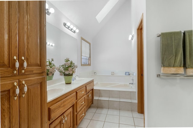 bathroom featuring vanity, vaulted ceiling with skylight, tile patterned flooring, and a relaxing tiled tub