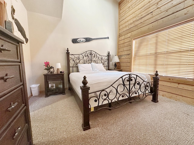 carpeted bedroom with wood walls