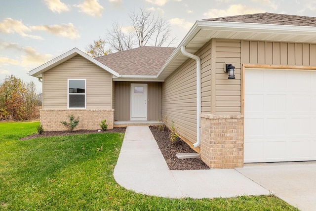 property entrance with a garage and a yard