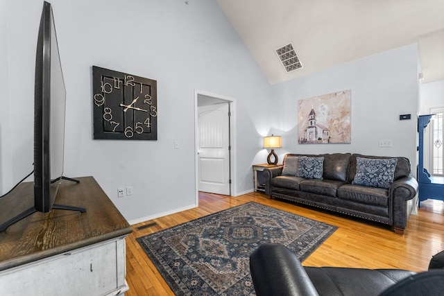 living room with high vaulted ceiling and wood-type flooring