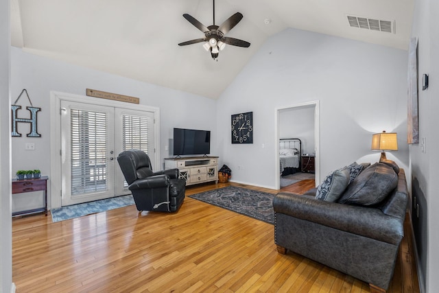 living room with french doors, ceiling fan, light hardwood / wood-style flooring, and high vaulted ceiling