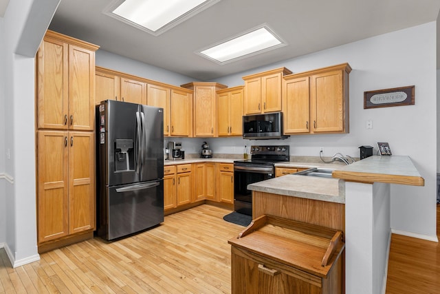 kitchen with sink, black electric range oven, stainless steel fridge with ice dispenser, kitchen peninsula, and a breakfast bar area