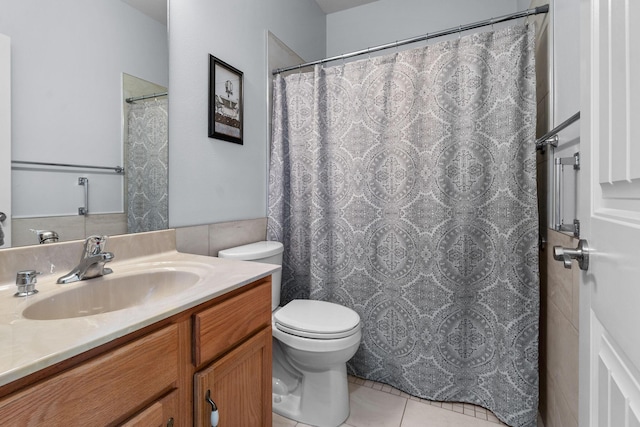 bathroom with toilet, vanity, and tile patterned flooring