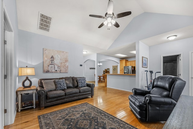 living room with vaulted ceiling, ceiling fan, and light hardwood / wood-style flooring