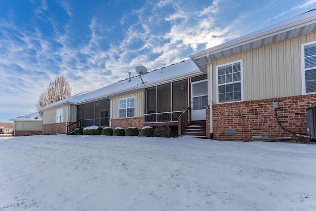 snow covered house with a sunroom