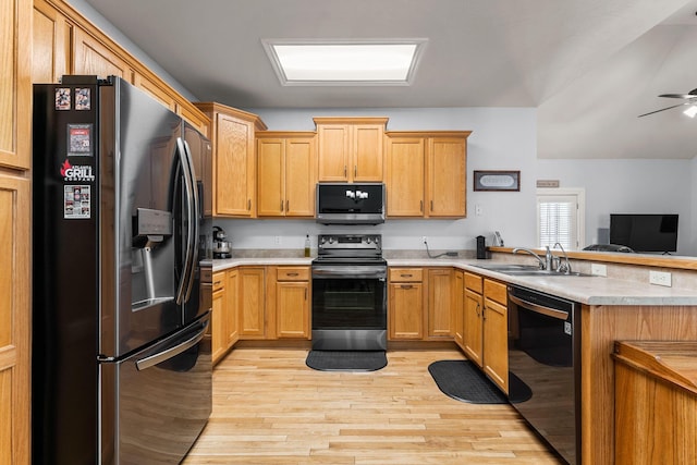 kitchen with kitchen peninsula, ceiling fan, stainless steel appliances, light hardwood / wood-style flooring, and sink