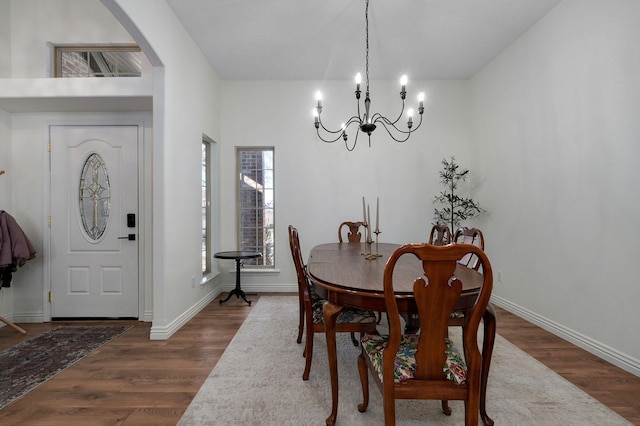 dining space featuring an inviting chandelier and dark hardwood / wood-style flooring