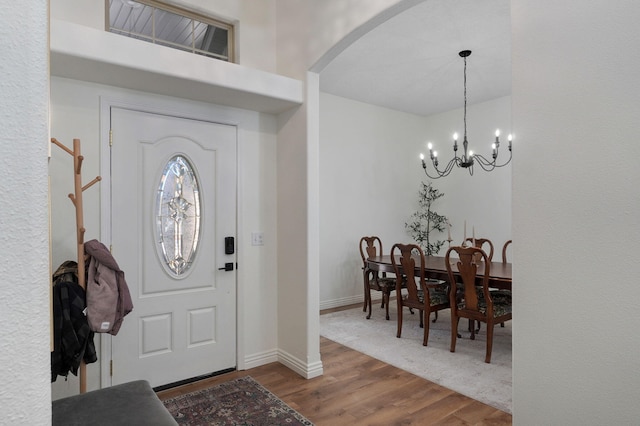 foyer entrance with an inviting chandelier and hardwood / wood-style floors