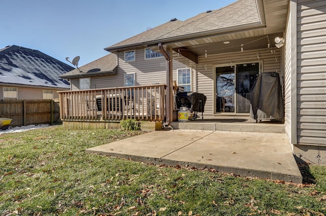 back of house featuring a deck, a lawn, and a patio