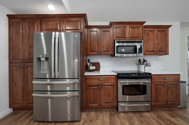 kitchen with backsplash, dark hardwood / wood-style floors, and stainless steel appliances