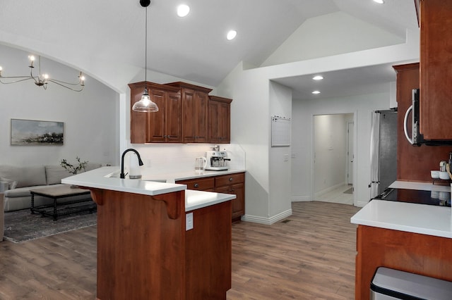 kitchen with kitchen peninsula, appliances with stainless steel finishes, pendant lighting, a breakfast bar, and sink