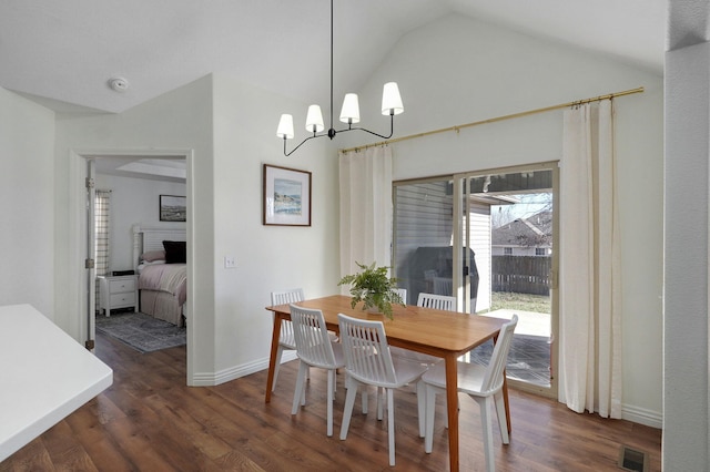 dining space with dark hardwood / wood-style floors, a chandelier, and vaulted ceiling