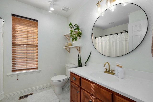 bathroom featuring toilet, a wealth of natural light, and vanity