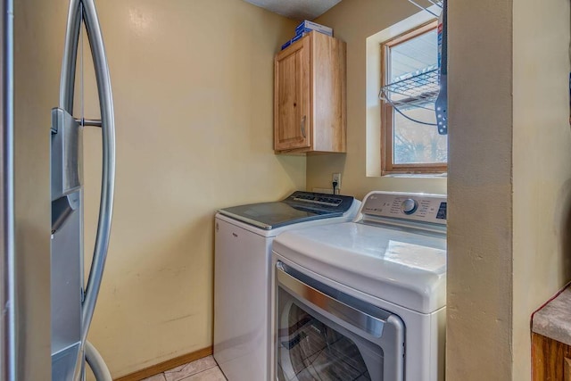 washroom with cabinets, light tile patterned flooring, and washing machine and clothes dryer